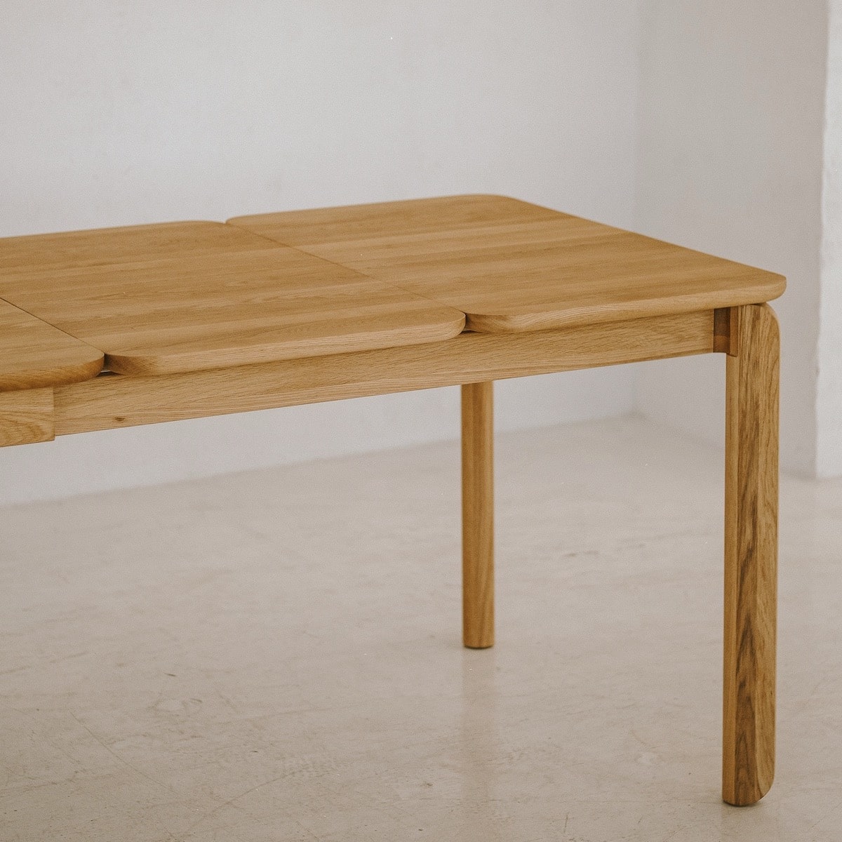 Close-up of BENO solid oak tabletop with smooth curved edge and natural finish