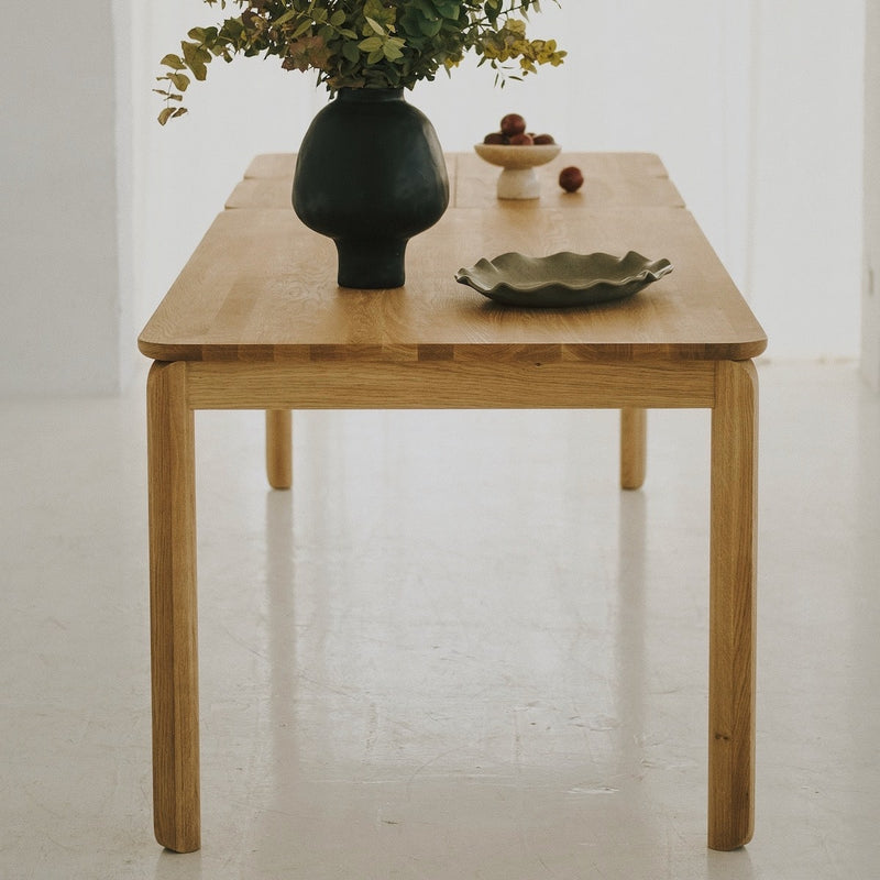 Elegant oak dining table with softly rounded corners and tapered solid wood legs